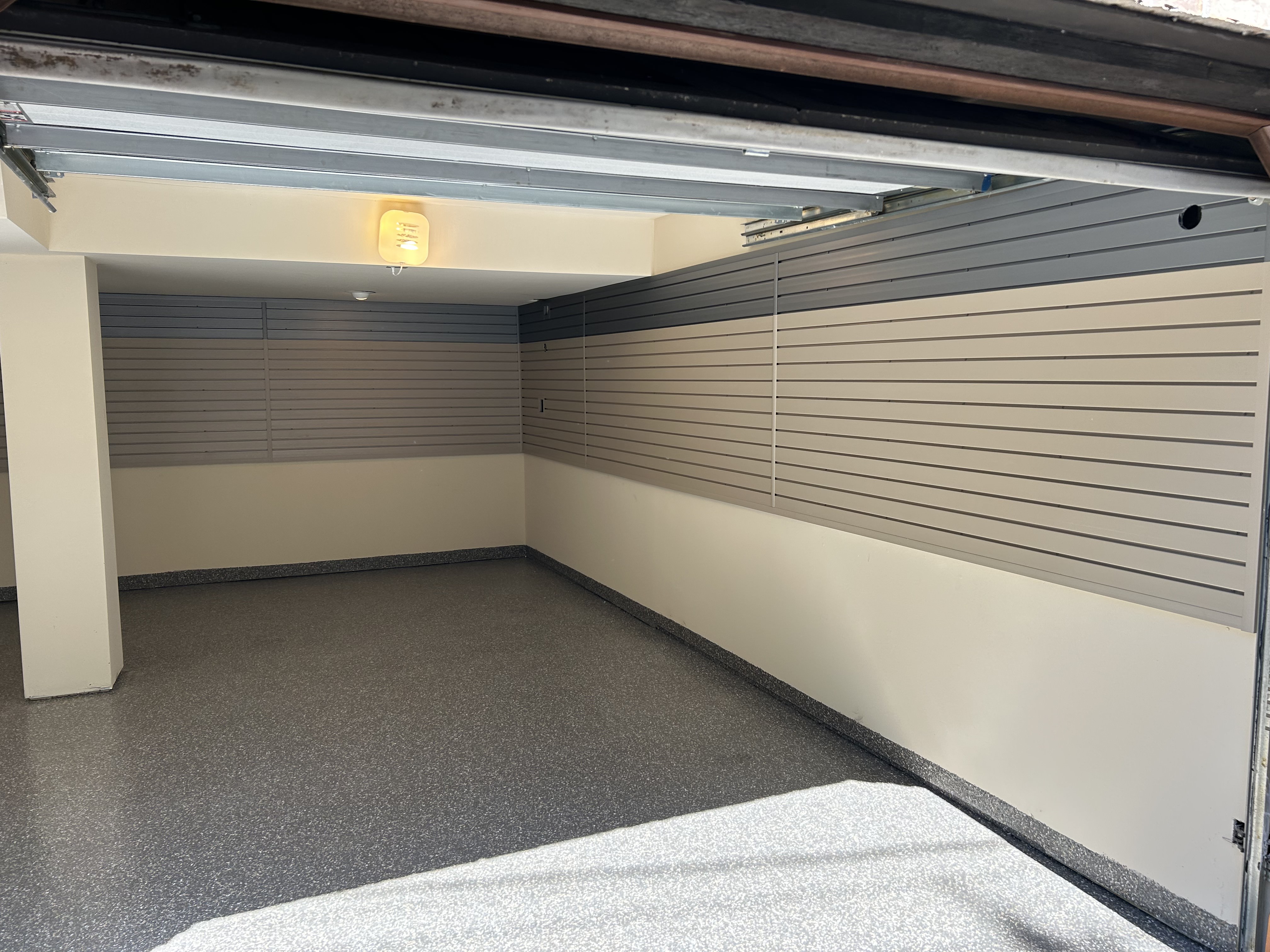 Garage with both polyaspartic floor coating and slatwall installation
